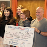 People Holding Large Check