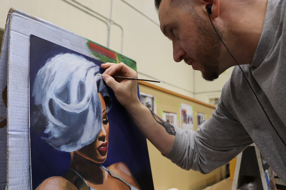 Man painting a woman with white hair
