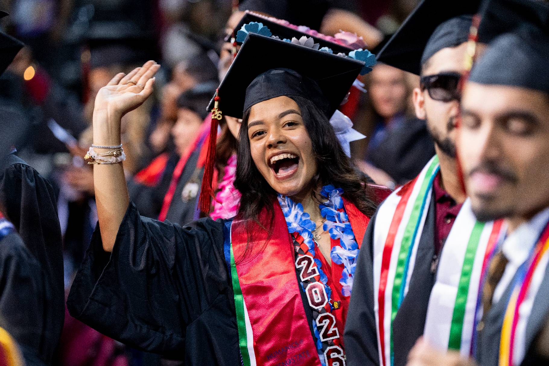 Female commencement student waving to the camera
